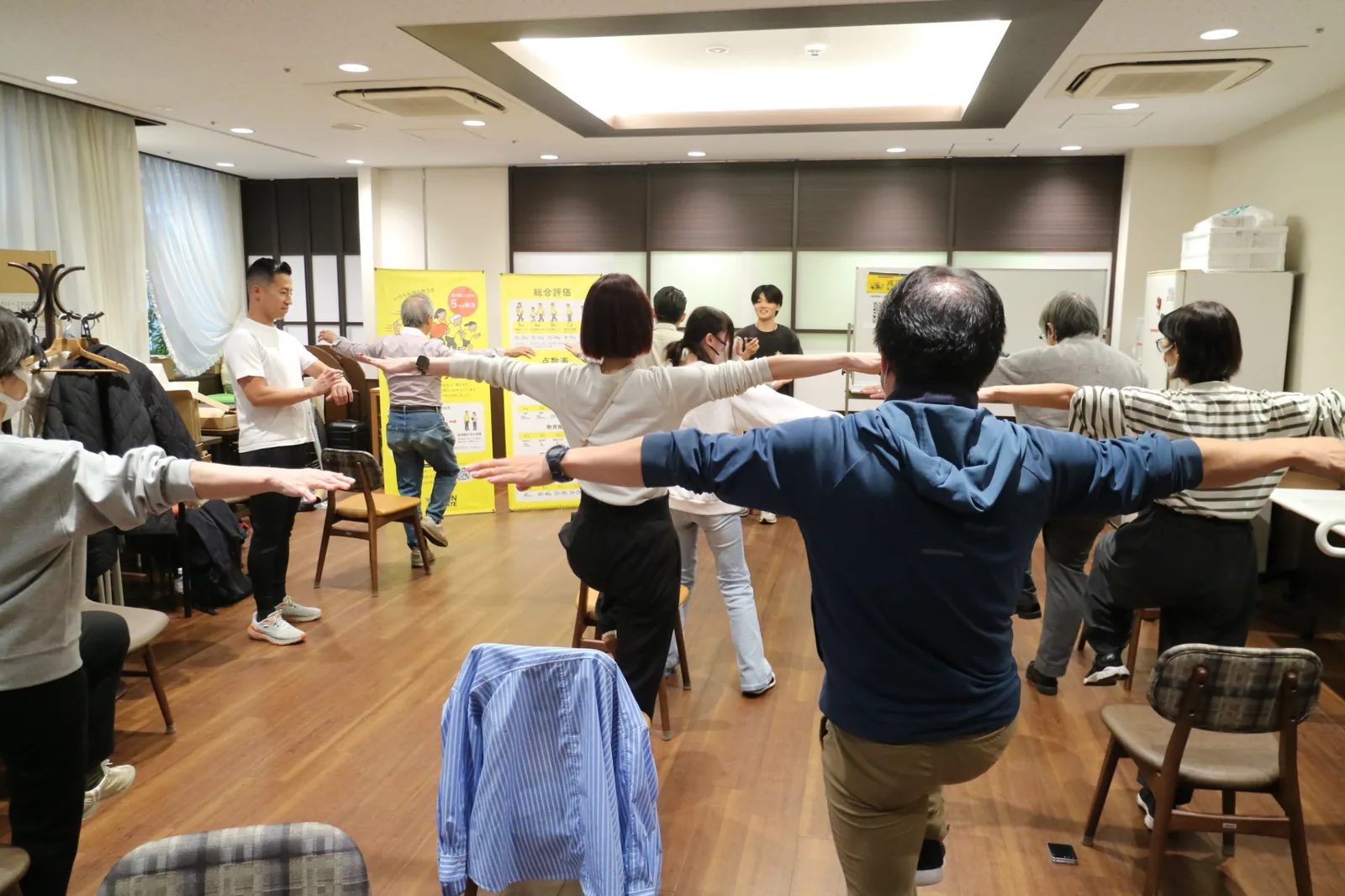 参加者が両腕を広げてバランス運動に取り組む減災体力測定の様子(山吹の里)