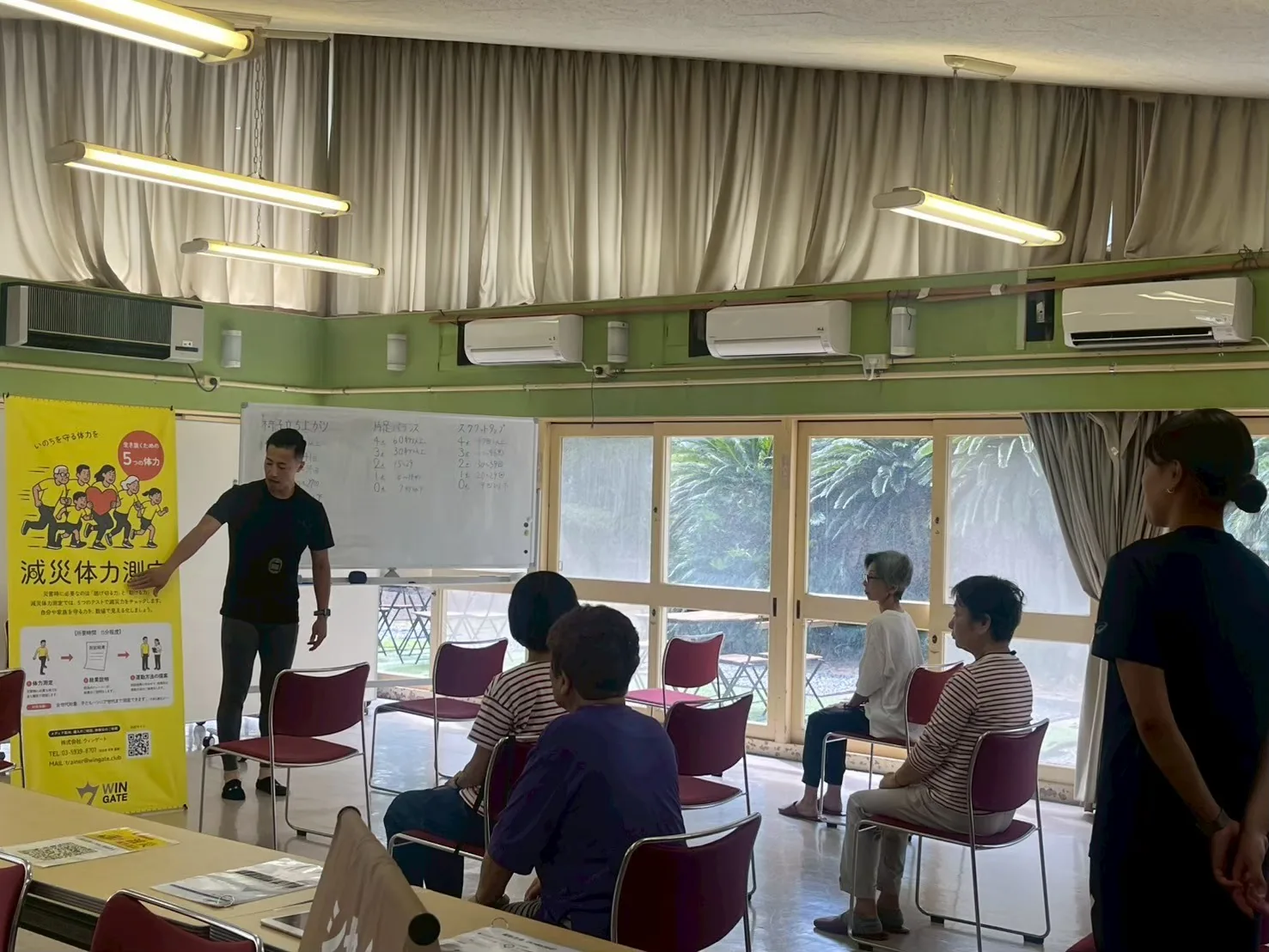 浜甲子園での減災体力測定。スタッフが測定の進め方を実演し参加者が見守る様子